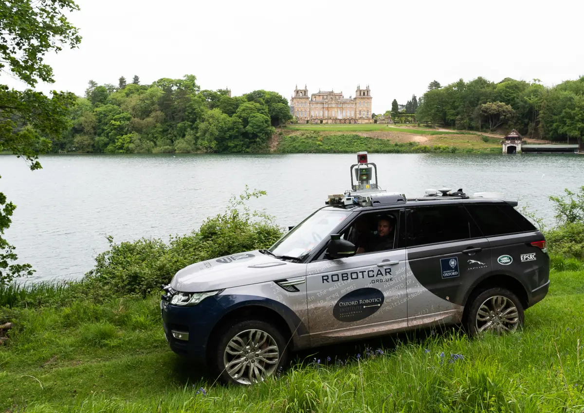 JLR Range rover parked on green grass in front of river.