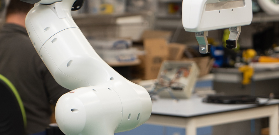 Panda robot arm on green table.